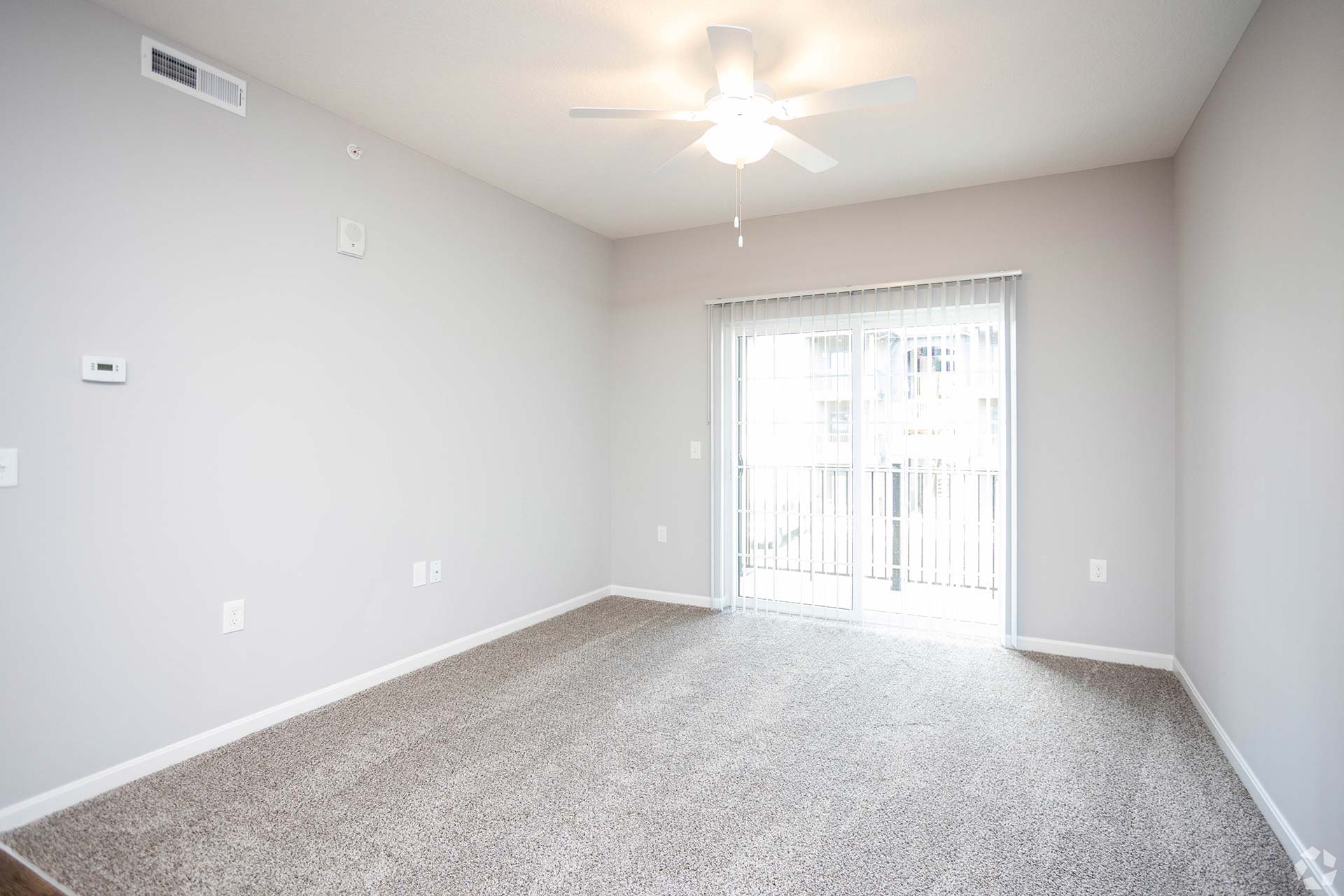 empty room with ceiling fan and carpeting at The Adams Pointe