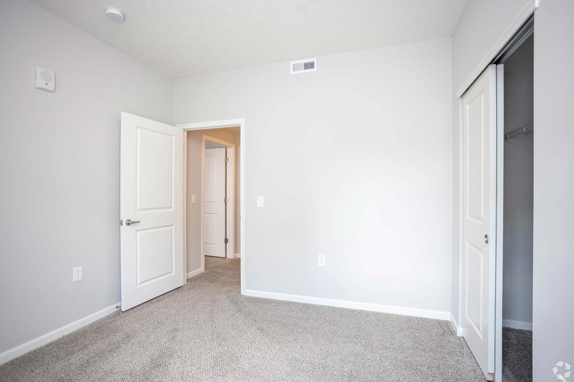 empty room with white carpet and closet doors at The Adams Pointe