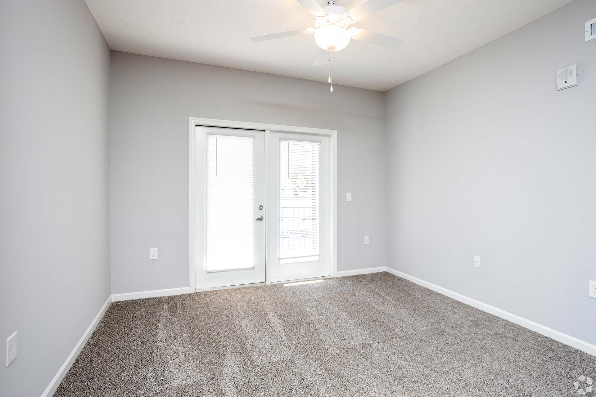 empty room with carpet and ceiling fan at The Adams Pointe